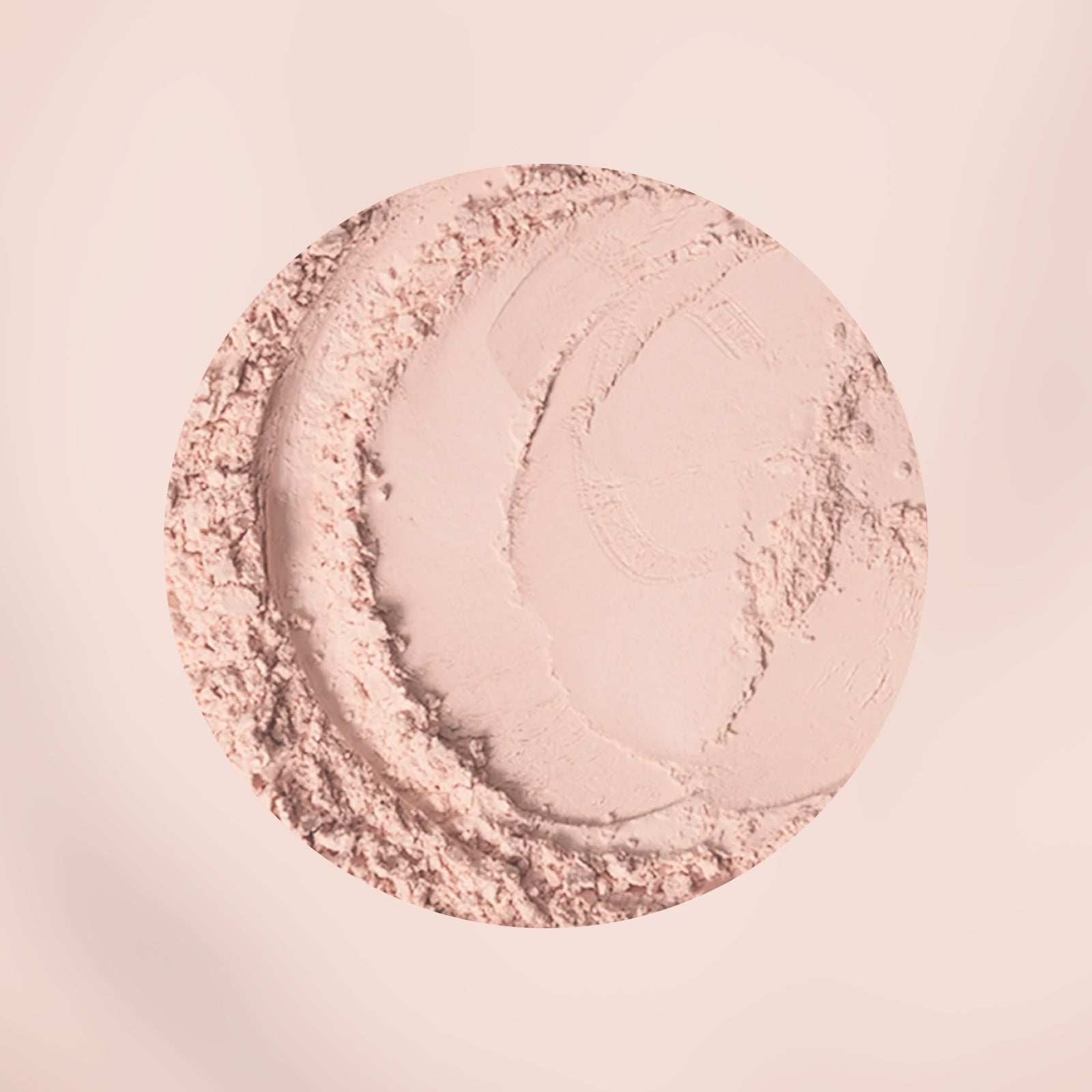 Nahaufnahme eines runden, beigen Puder-Make-up-Produkts mit strukturierten Rändern und geschwungenen Abdrücken auf einem hellen, neutralen Hintergrund.